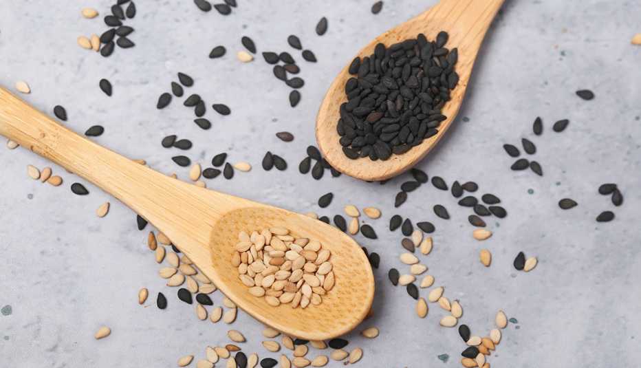 sesame and black sesame seeds in wooden spoons