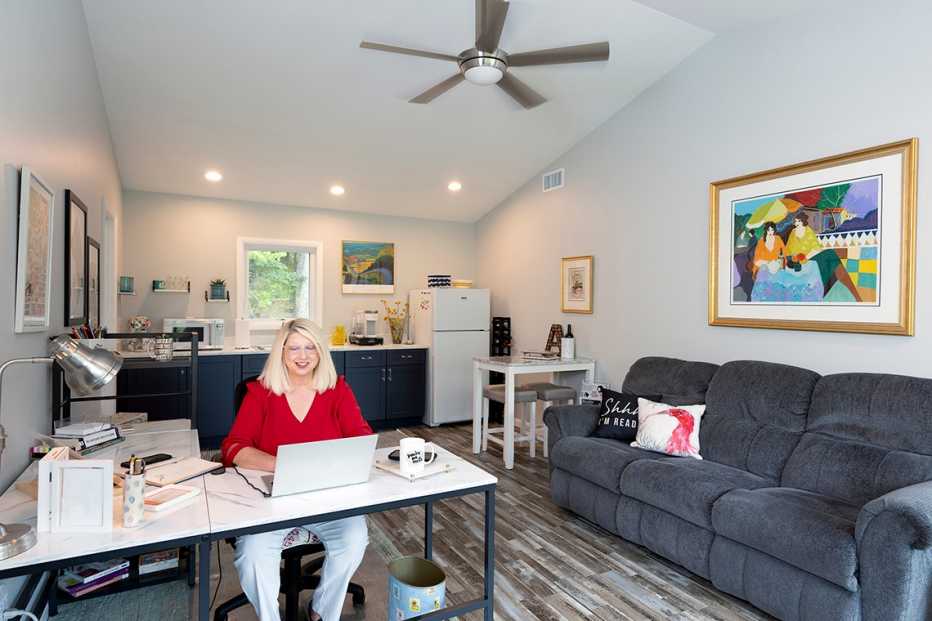 ann davidson sitting at a desk in the living space she and her husband jim had built over a garage