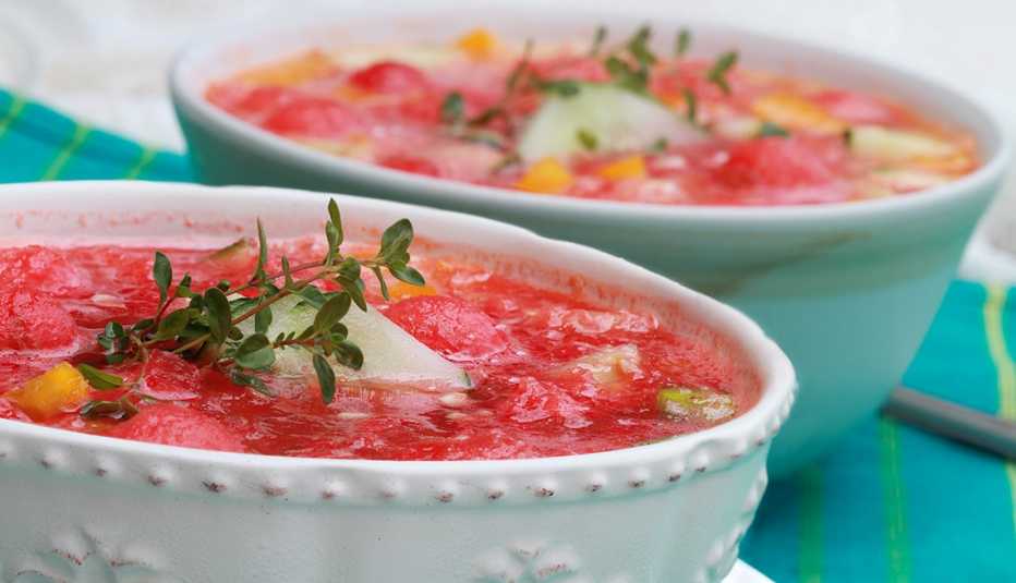 Watermelon Gazpacho made with watermelon, yellow peppers, cucumber, and garnished with a sprig of fresh thyme