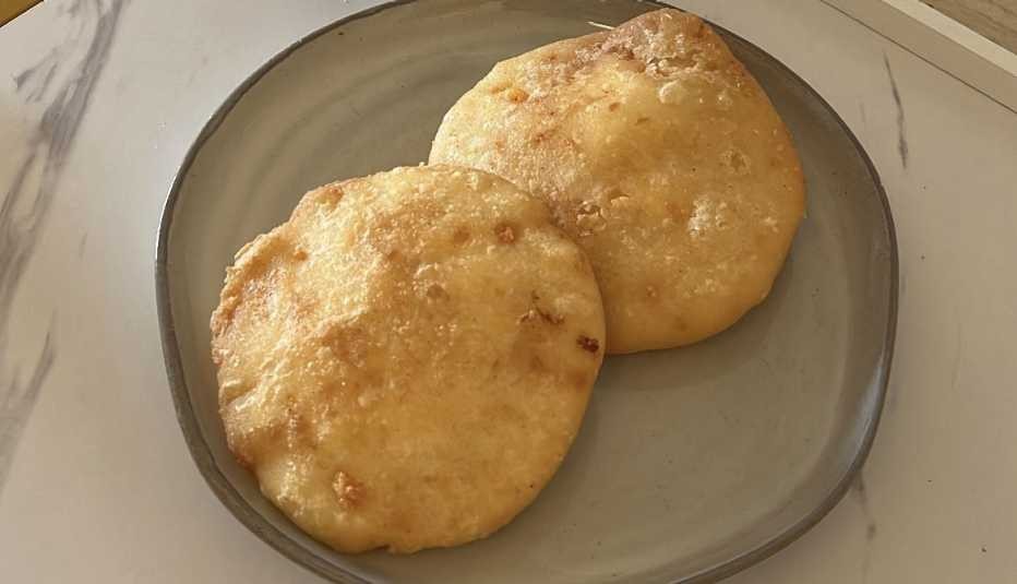 two egg-stuffed arepas on a plate