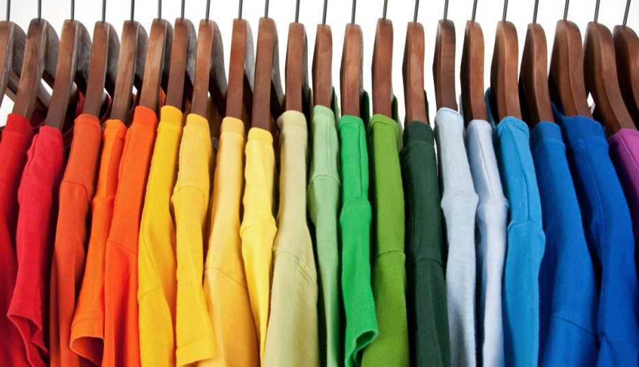 a rainbow of shirts on hangers