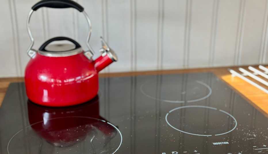 a red kettle on an induction stove