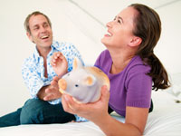 Smiling couple and piggy bank, Jeff Yeager, Married to a cheapskate is beneficial