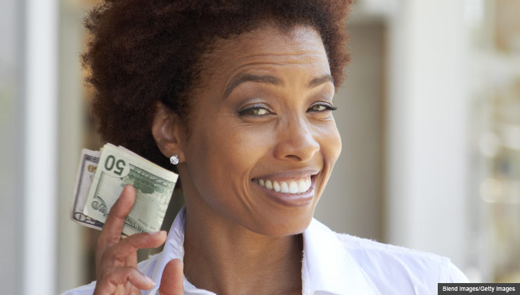 Woman smiling holding money, make financial resolutions for 2013