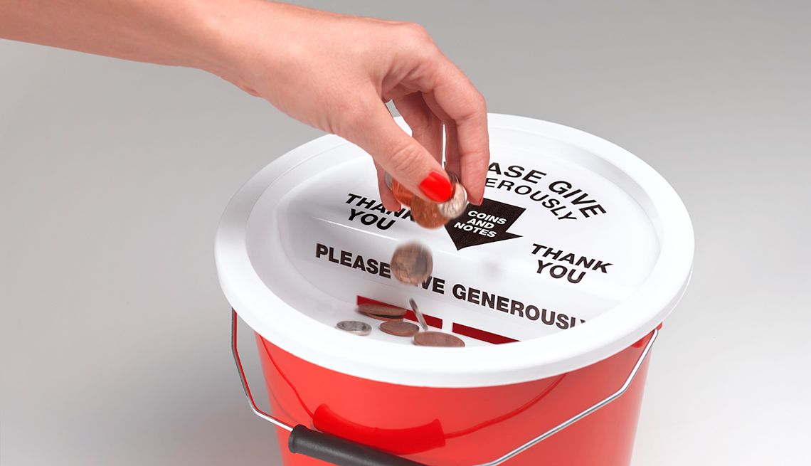 Hand putting change in collection bucket