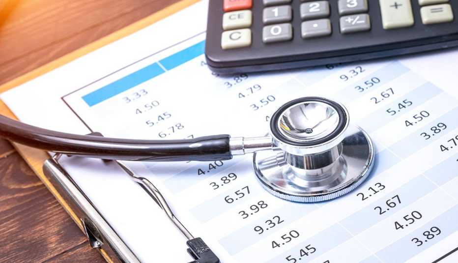 Stethoscope on clipboard with financial information with calculator in the background