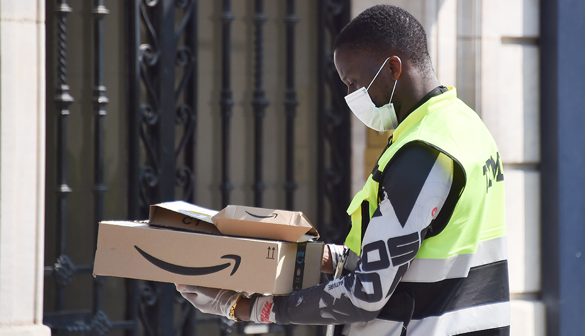 An Amazon delivery driver wears protective face mask and gloves while delivering packages during the coronavirus pandemic