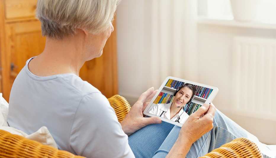  woman with tablet pc during an online consultation with her doctor in her living room