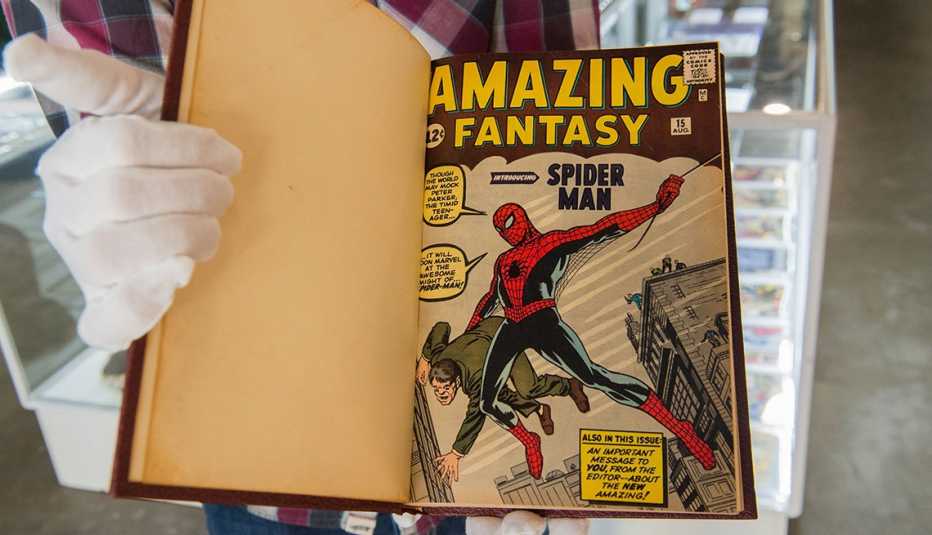 White gloved hand holds a valuable bound book of rare Spider-Man comics
