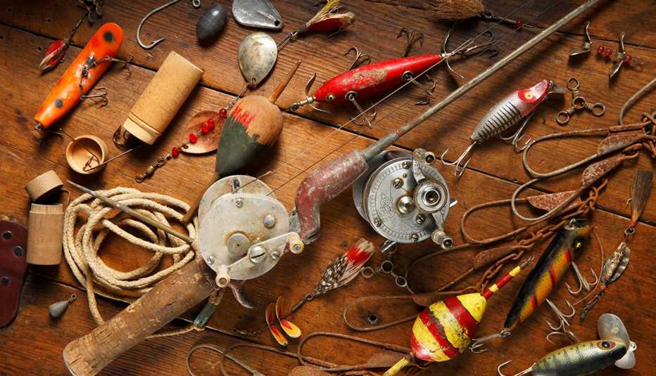 A colorful assortment of antique fishing gear is displayed on a wooden tabletop.
