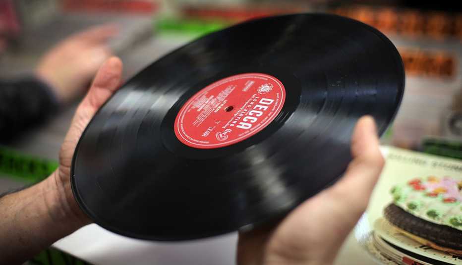 closeup of hands holding a vintage vinyl record album