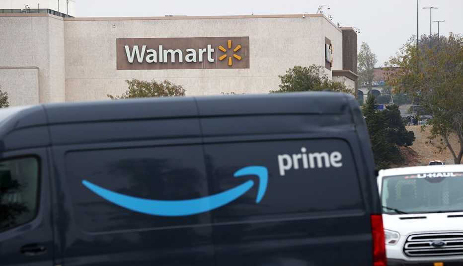 An Amazon Prime delivery van sits parked near a Walmart store.
