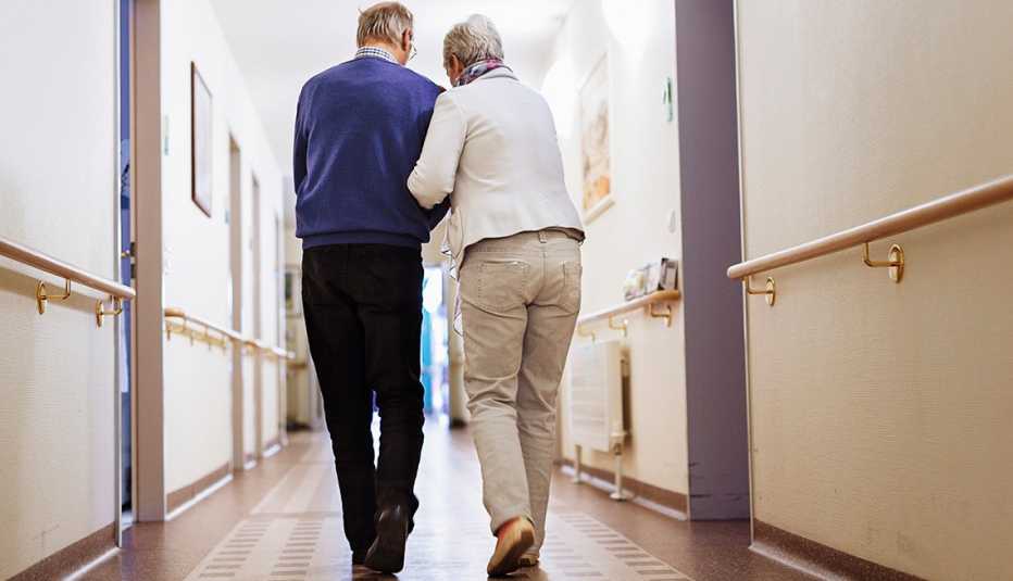 An older couple walking down the hall