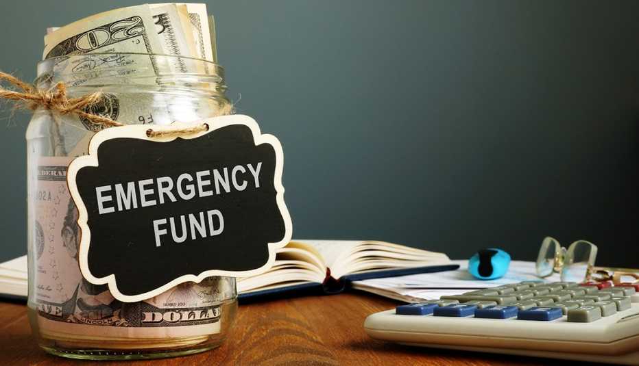 a savings jar full of money has a tag that says "Emergency Fund"
