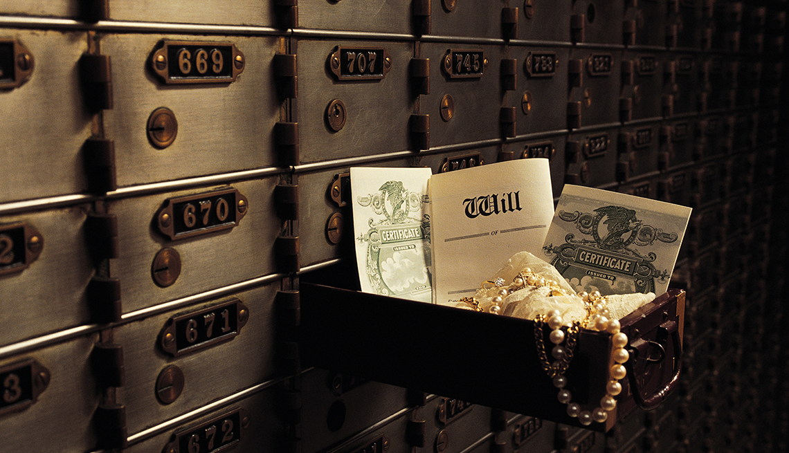 Open safe deposit box in bank vault revealing contents including will, stock certificates and jewelry