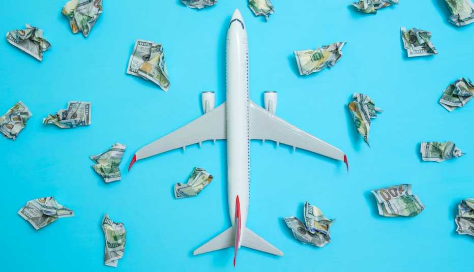 an airplane surrounded by crumpled hundred dollar bills
