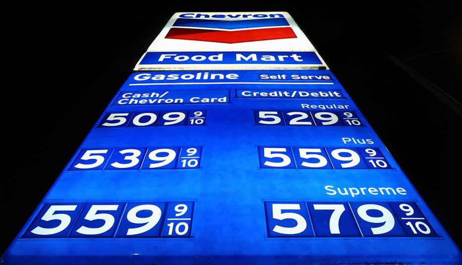Looking up at a bright blue sign against a black background displaying gasoline climbing to record high prices  February 08, 2022 in Los Angeles, California. 