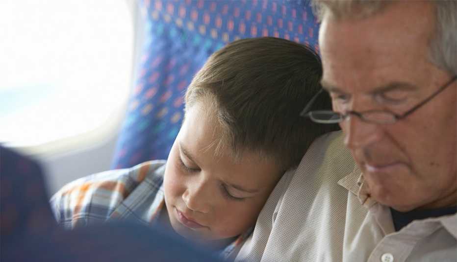 grandson sitting next to grandpa on airplane
