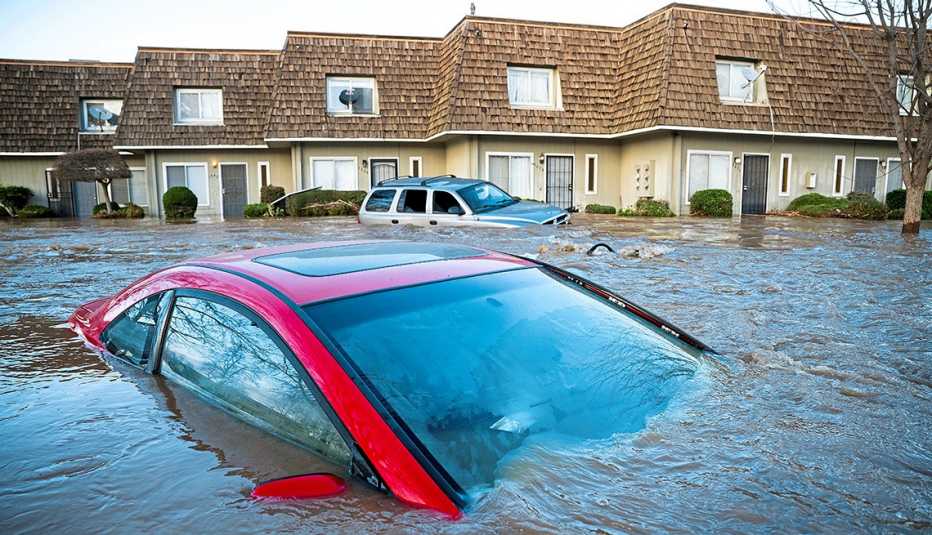 Flooded car and apartment building. Floodwaters course through a neighborhood in Merced, Calif., on Tuesday, Jan. 10, 2023.