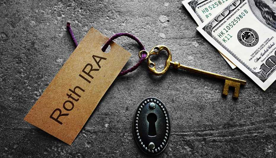 A display of a key that is labeled "Roth IRA" next to a keyhole and hundred dollar bills.