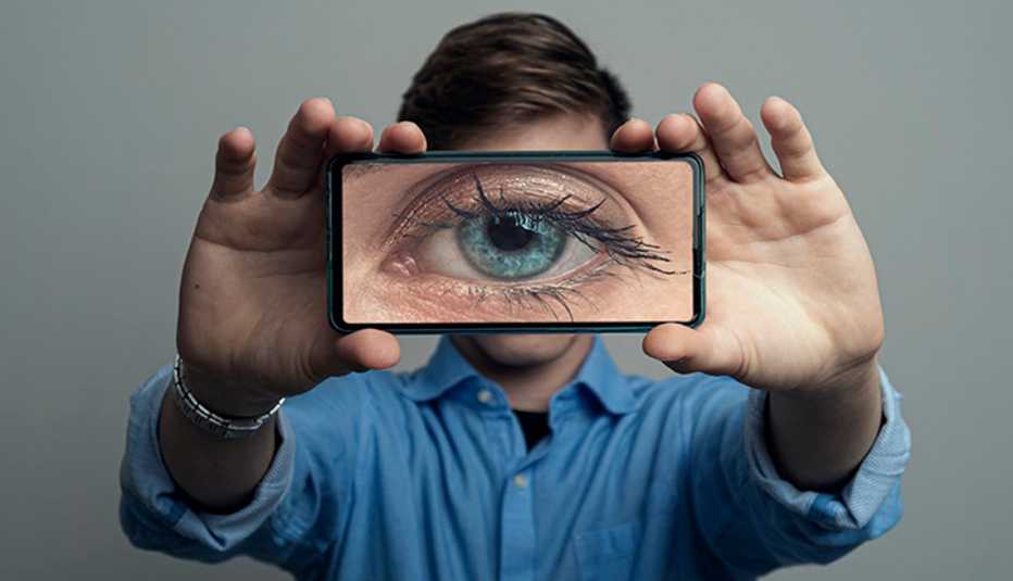 a man holds a camera screen featuring an eye in front of himself