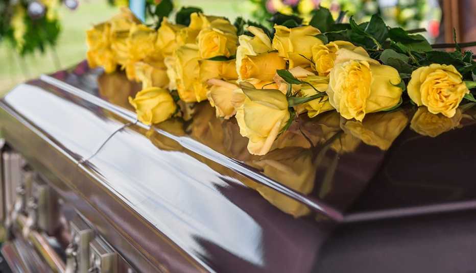 a casket with yellow flowers on top