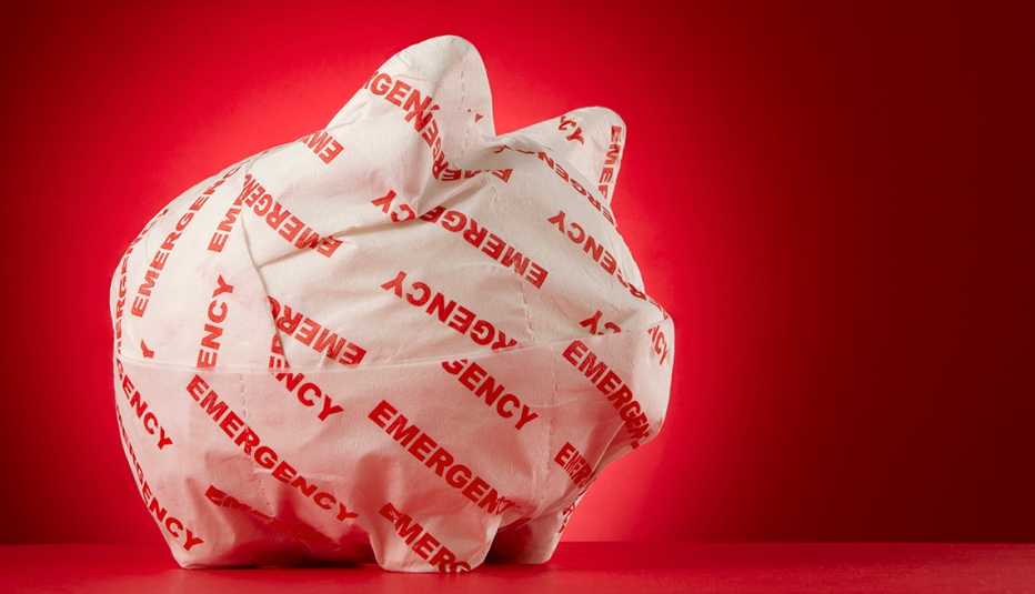 piggy bank wrapped with emergency paper in front of a red background
