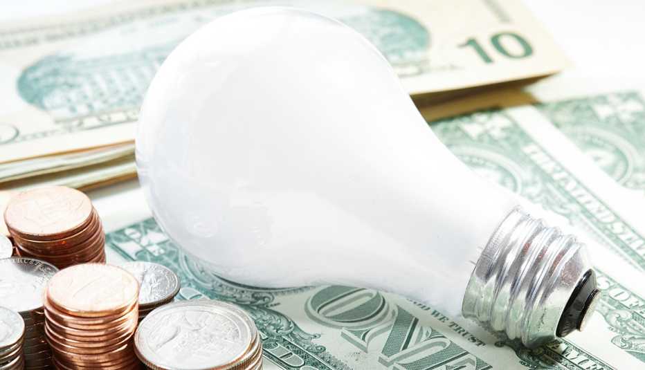 light bulb on top of US currency stacks