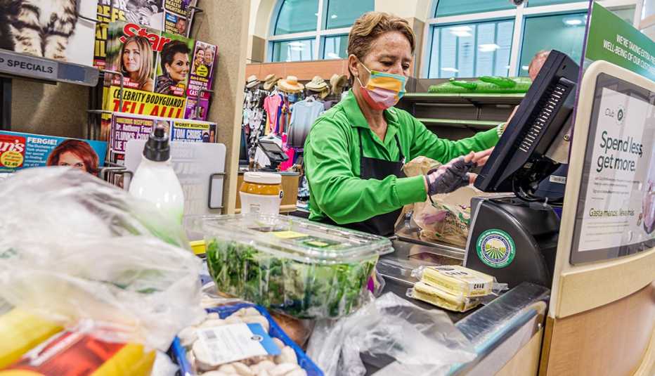 Cashier ringing up groceries on a conveyer belt at a  Publix supermarket in Florida.