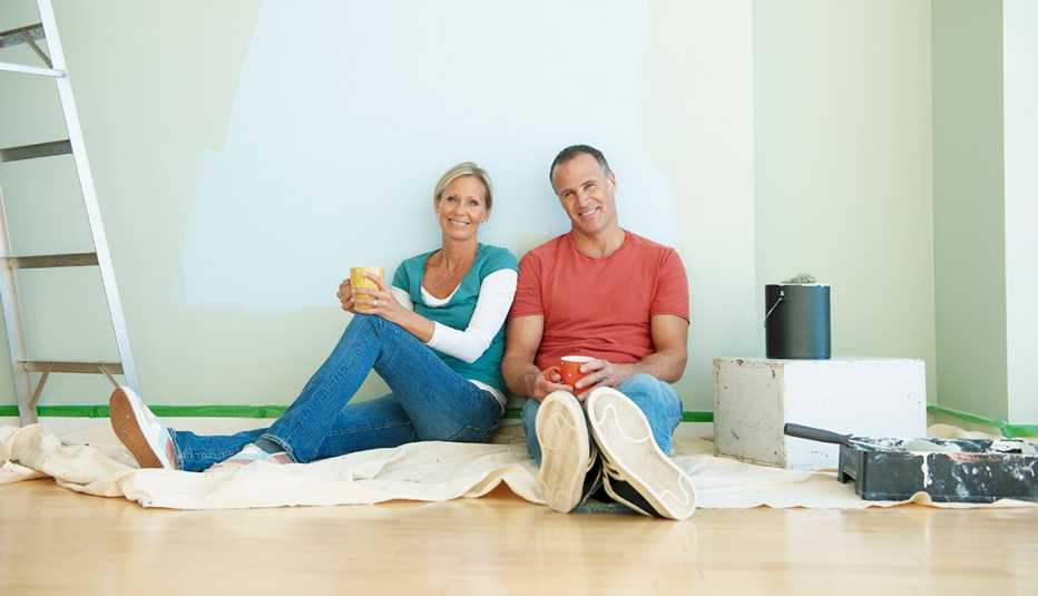 Couple resting after painting a wall