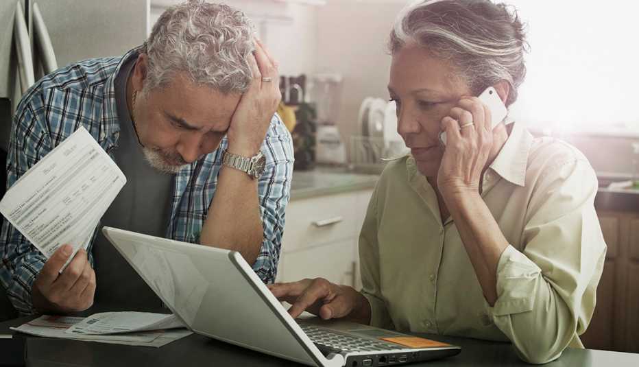 Stressed mature couple reviewing financial statements for suspicious activity