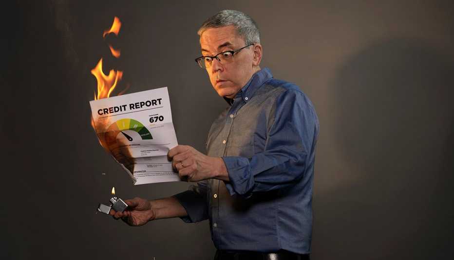george mannes in a comical pose setting fire to his credit report with a zippo lighter