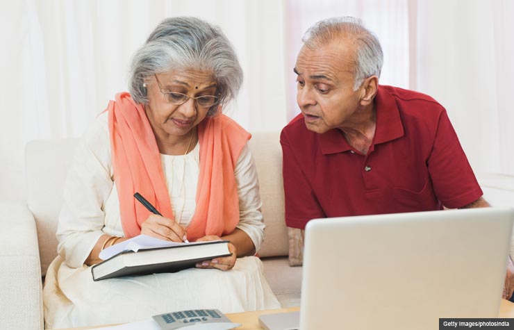 Senior couple paying bills on computer (Getty Images/photosindia)