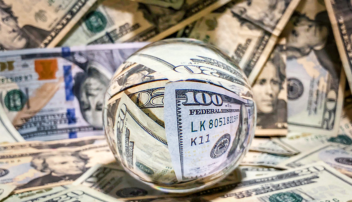 A reflective  surface crystal ball surrounded by money