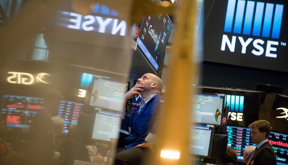 Wall Street trader looking up at screens