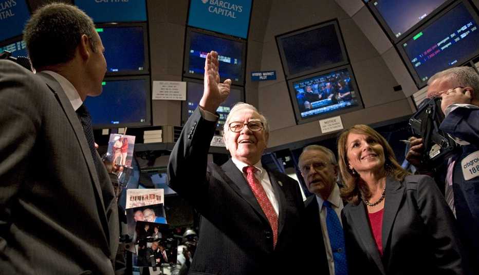 Warren Buffett, chairman and chief executive officer of Berkshire Hathaway Inc., center, waves as he tours floor of the New York Stock Exchange
