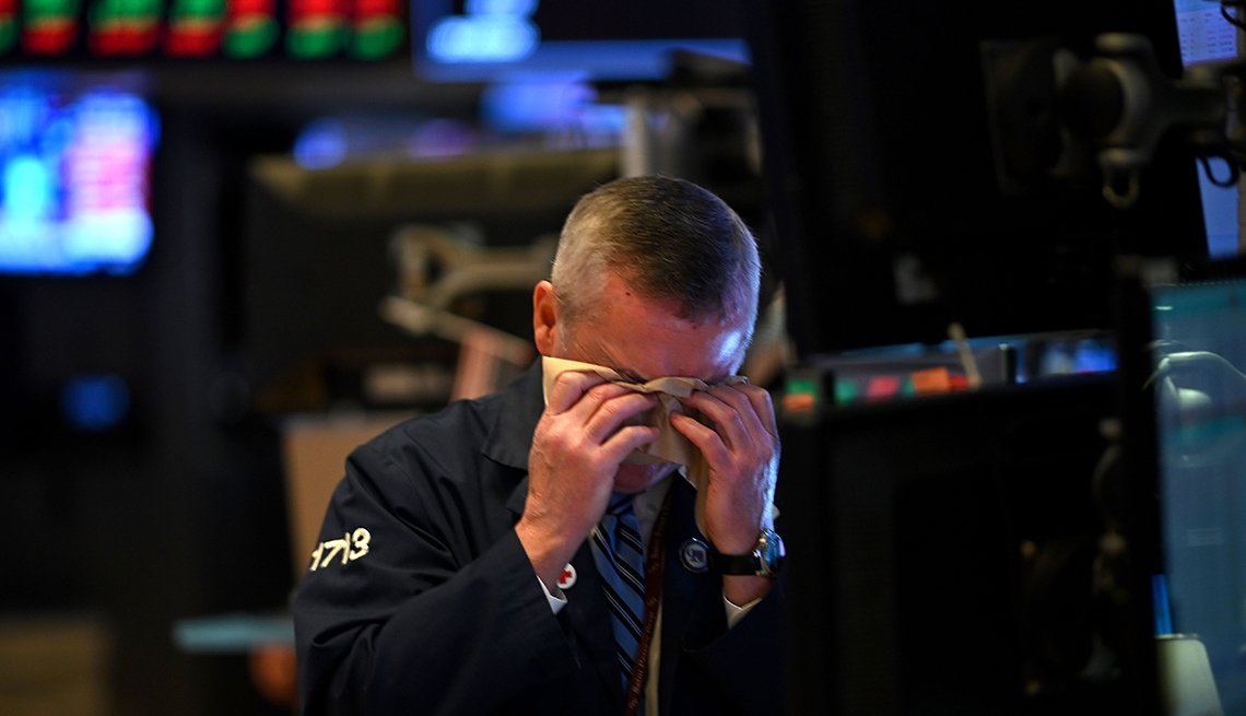 A man wipes his face on the floor of the New York Stock Exchange