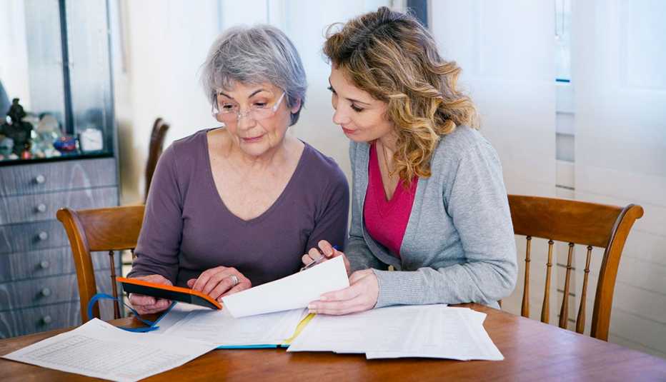A daughter helping her elderly mother organize her financial records and legal documents
