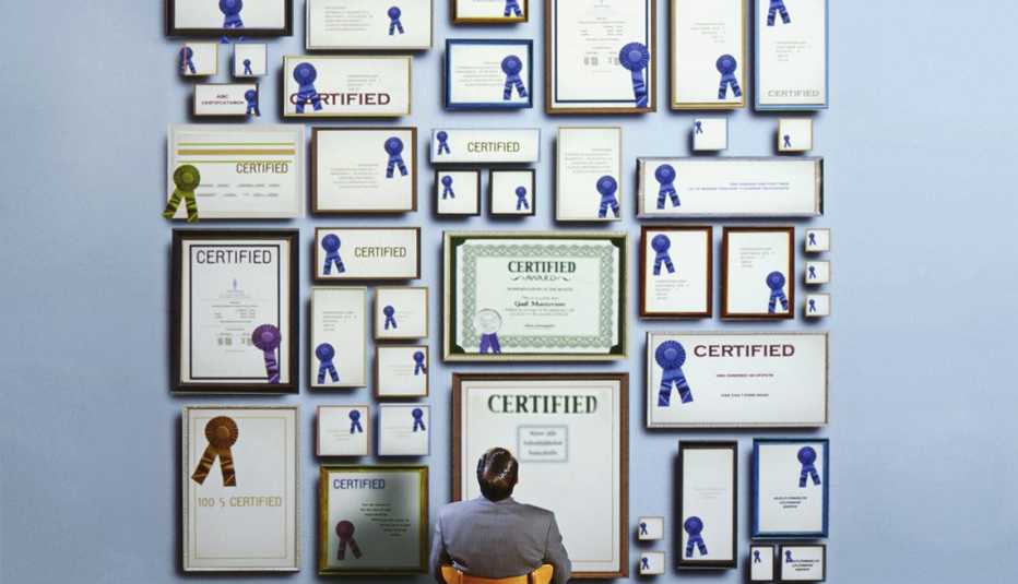 view from behind a man looking up at a wall filled with framed certificates with impressive blue ribbons that look fake