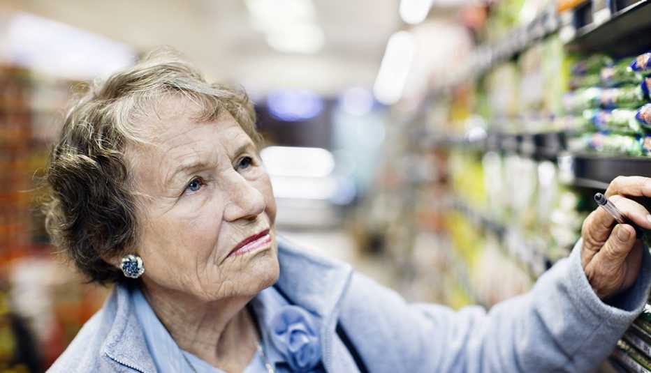 serious supermarket shopper taking a close look at products on shelves
