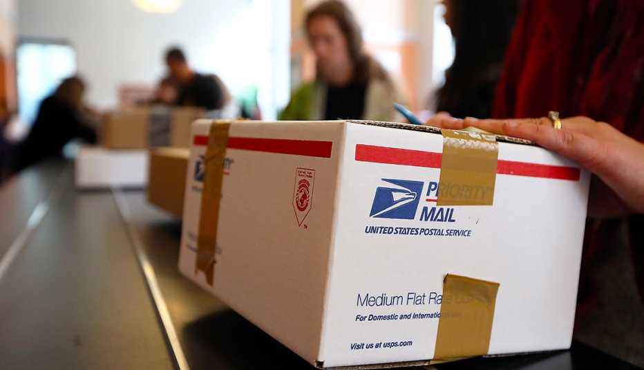 A customer is waiting in line at the post office to ship a holiday package