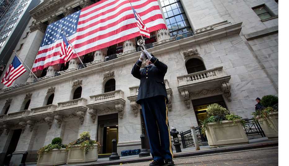 A member of the National Guard plays a trumpet during a flag raising ceremony in honor of Veteran's Day in front of the New York Stock Exchange (NYSE) in New York
