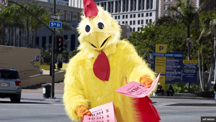 person in chicken suit handing out flyers
