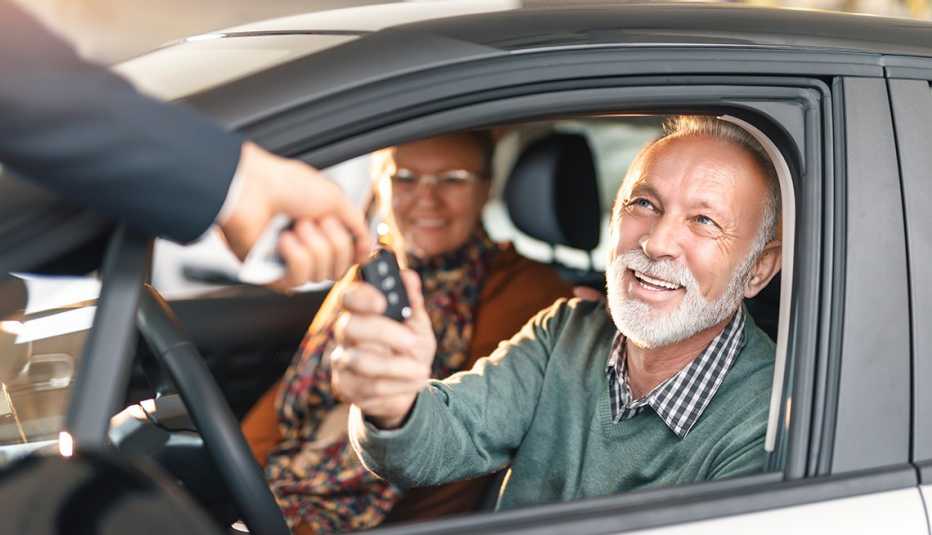 boomers sitting in car, getting handed keys to new car