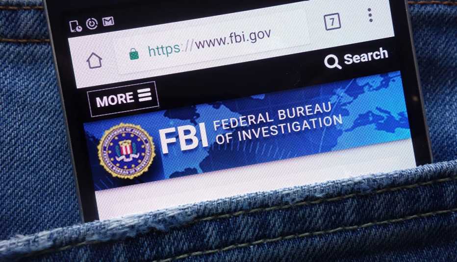 FBI (Federal Bureau of Investigation) website displayed on smartphone hidden in jeans pocket