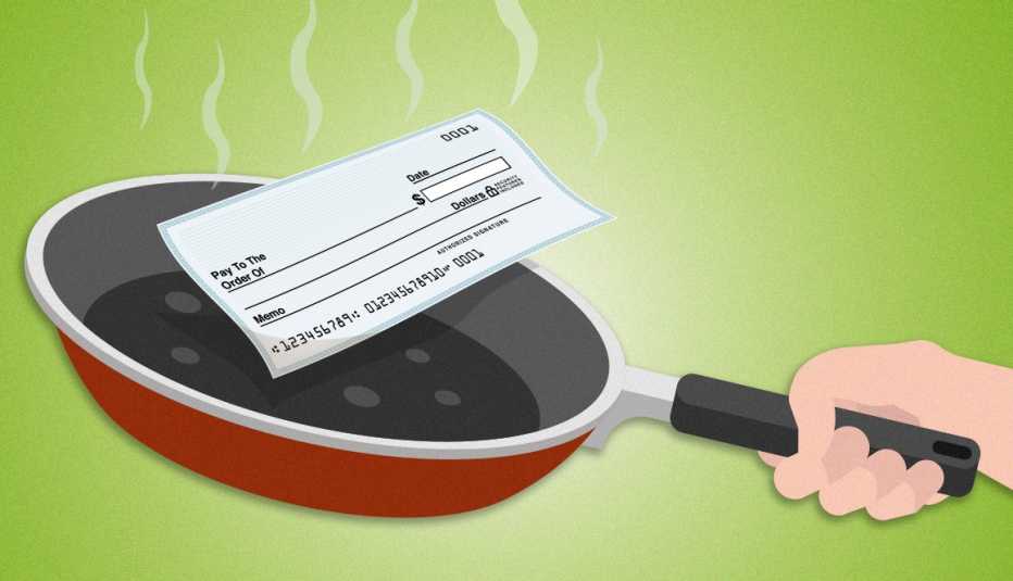 hand holding hot frying pan with a personal check inside of it cooking and steam rising from it