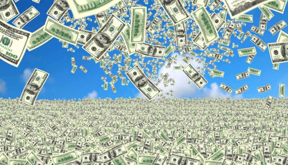 the ground is covered with 100 dollar bills and cash is also raining down from a bright blue sky