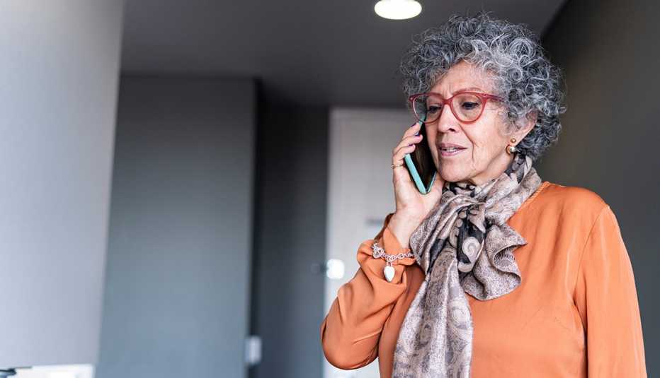 Woman of Latino ethnicity aged between 60-70 years is using the cell phone in times of quarantine by COVID-19