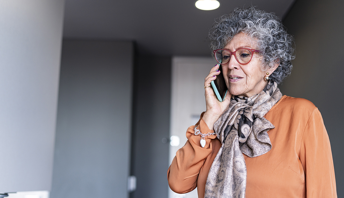 Woman of Latino ethnicity aged between 60-70 years is using the cell phone in times of quarantine by COVID-19