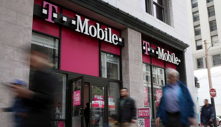 people walk in front of a t-mobile store front